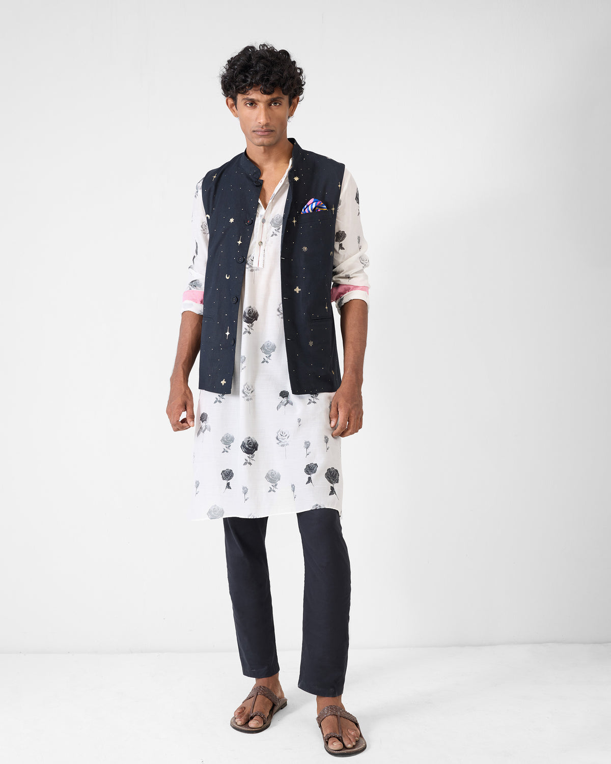 Person wearing a light grey Astral kurta with rose print under a navy jacket.