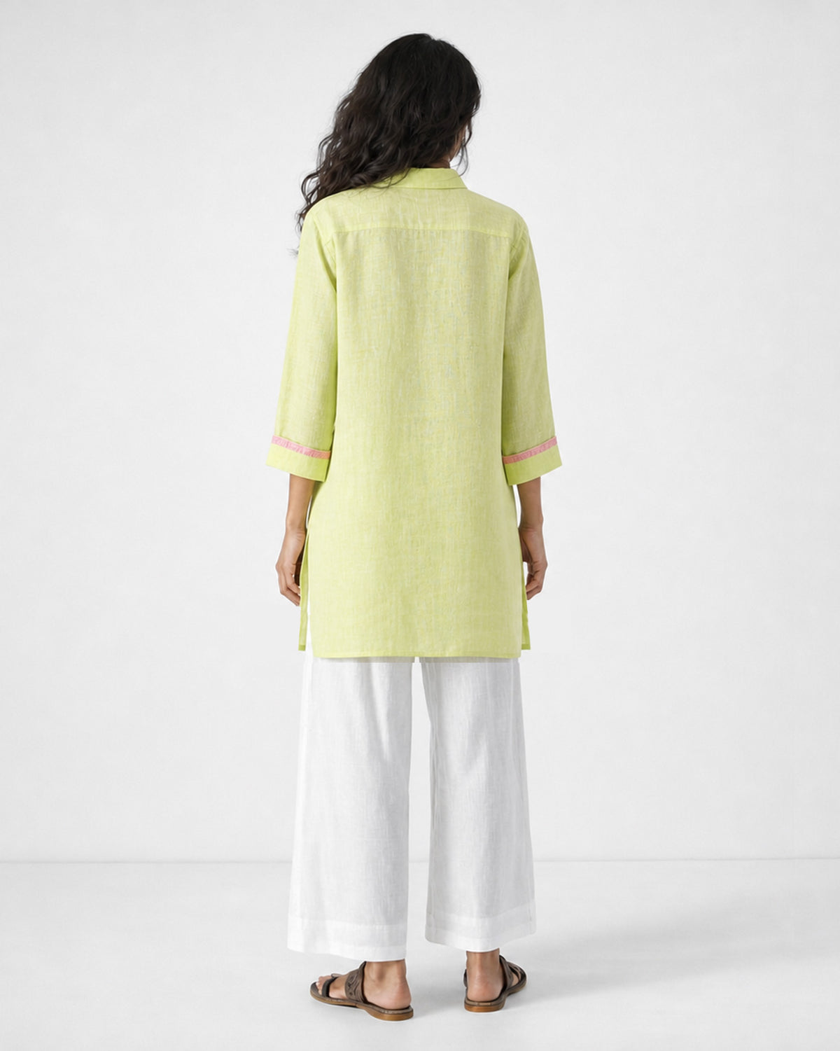 Back of a light green Fort kurta with pink sleeve trim worn by a person.