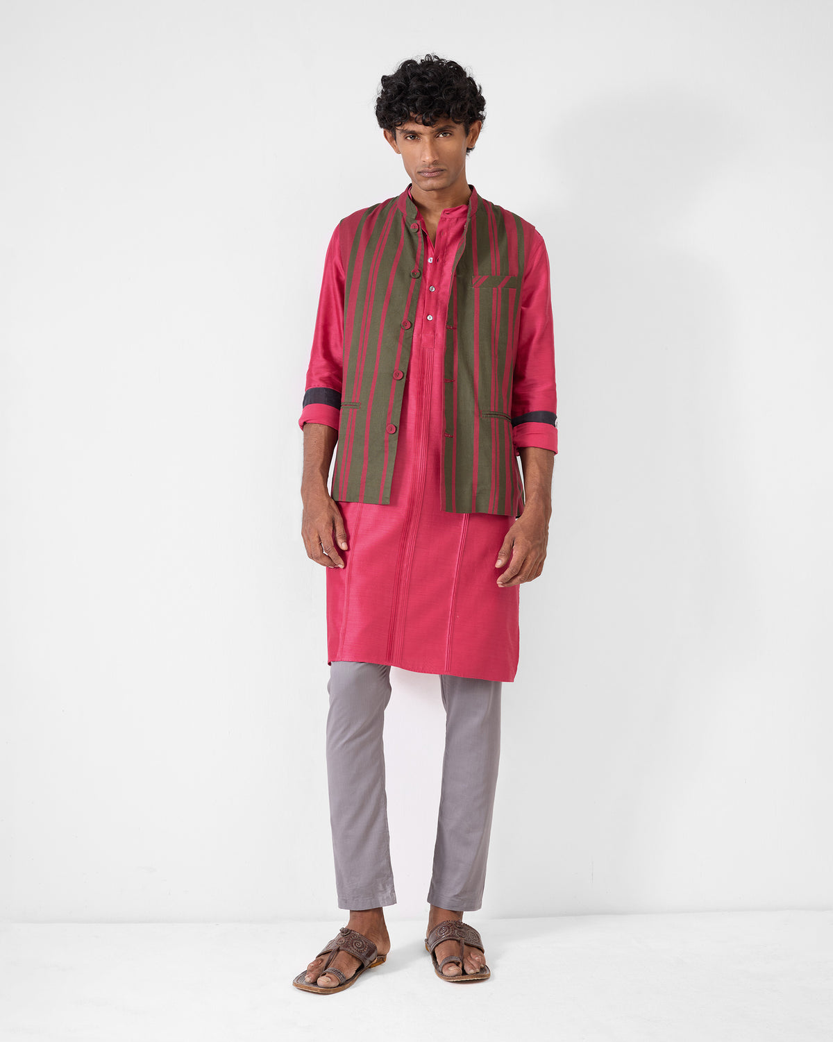 Person wearing a watermelon Naaz kurta under a striped Nehru jacket.