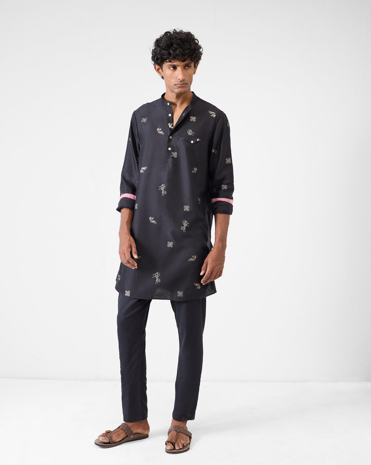 Person wearing a black Fort Kurta with silver foil print and pink cuff lining.