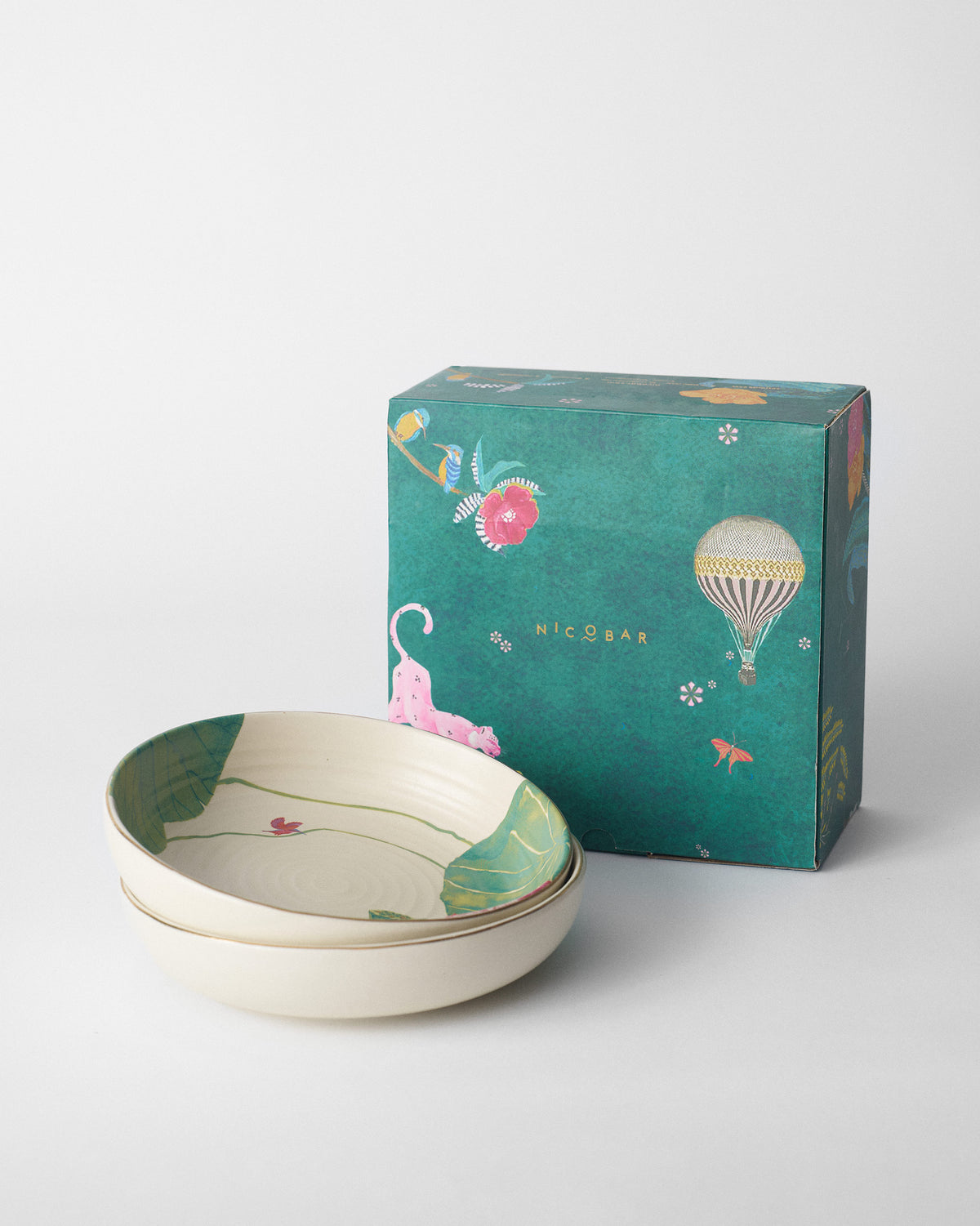 Lotus Garden shallow bowls stacked beside a teal Nicobar gift box.