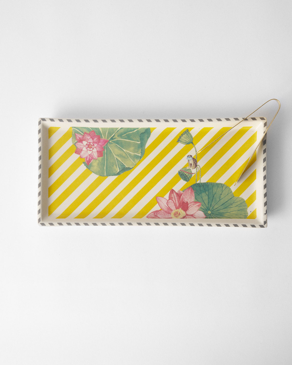 Overhead view of yellow Lotus Garden tray with lotuses and brass tongs.