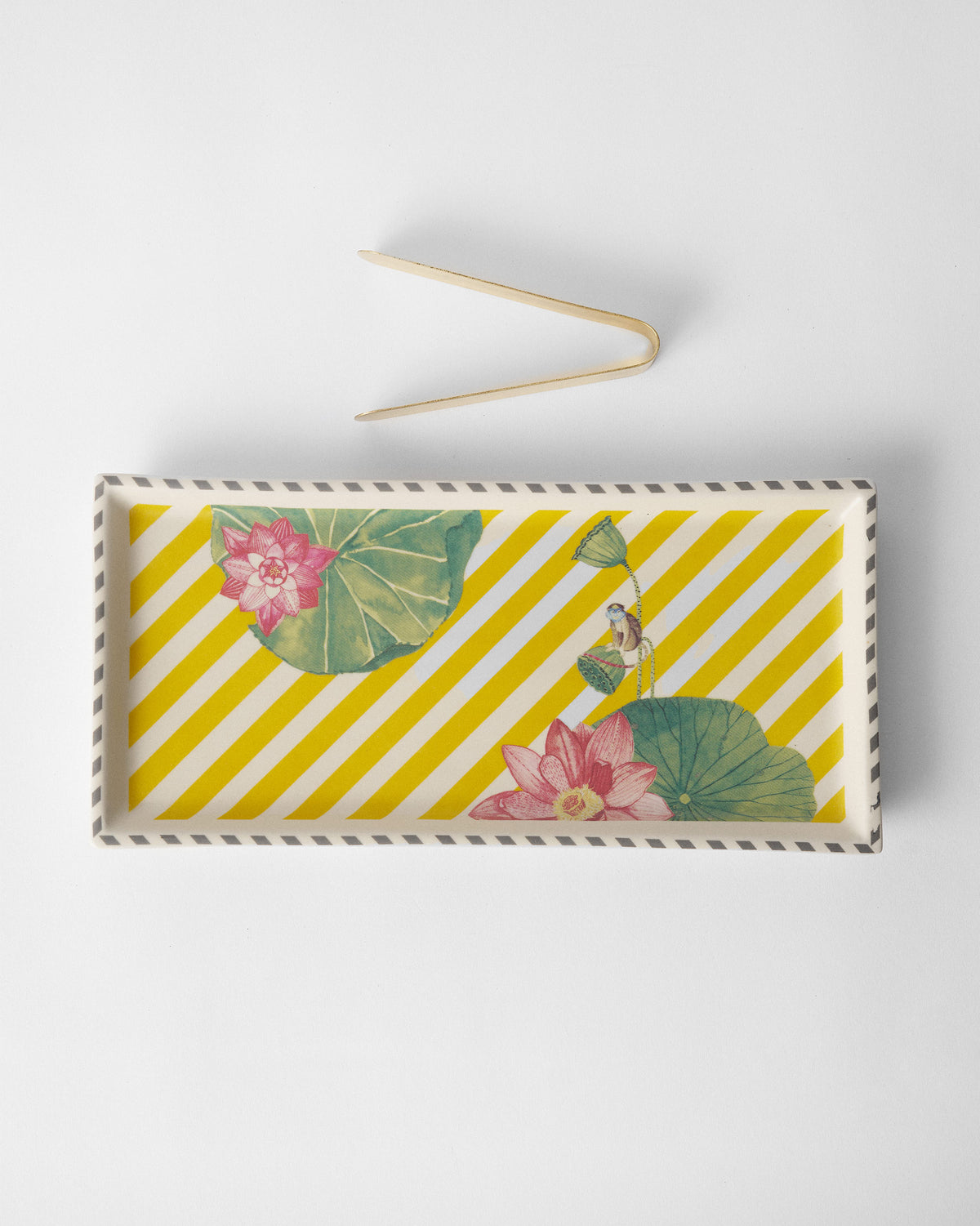 Yellow Lotus Garden cookie tray with matching tongs beside it.