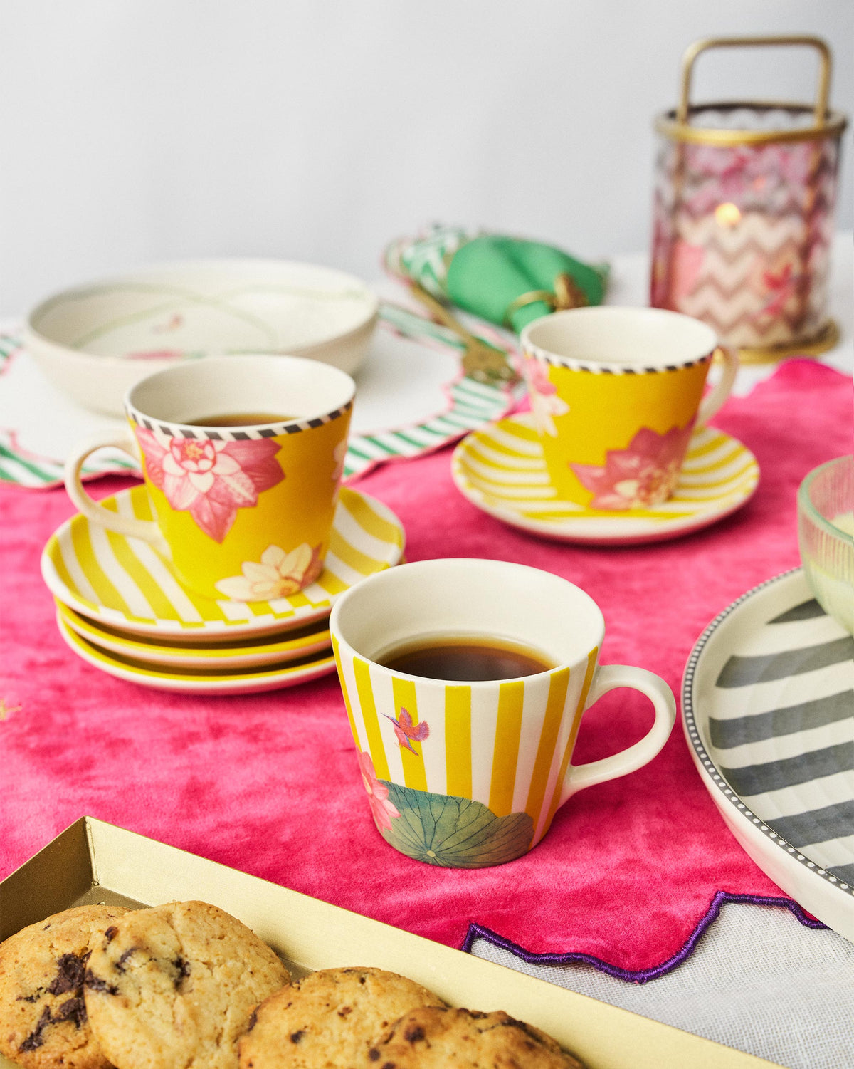 Lotus Garden espresso mugs with coffee on a pink tablecloth.