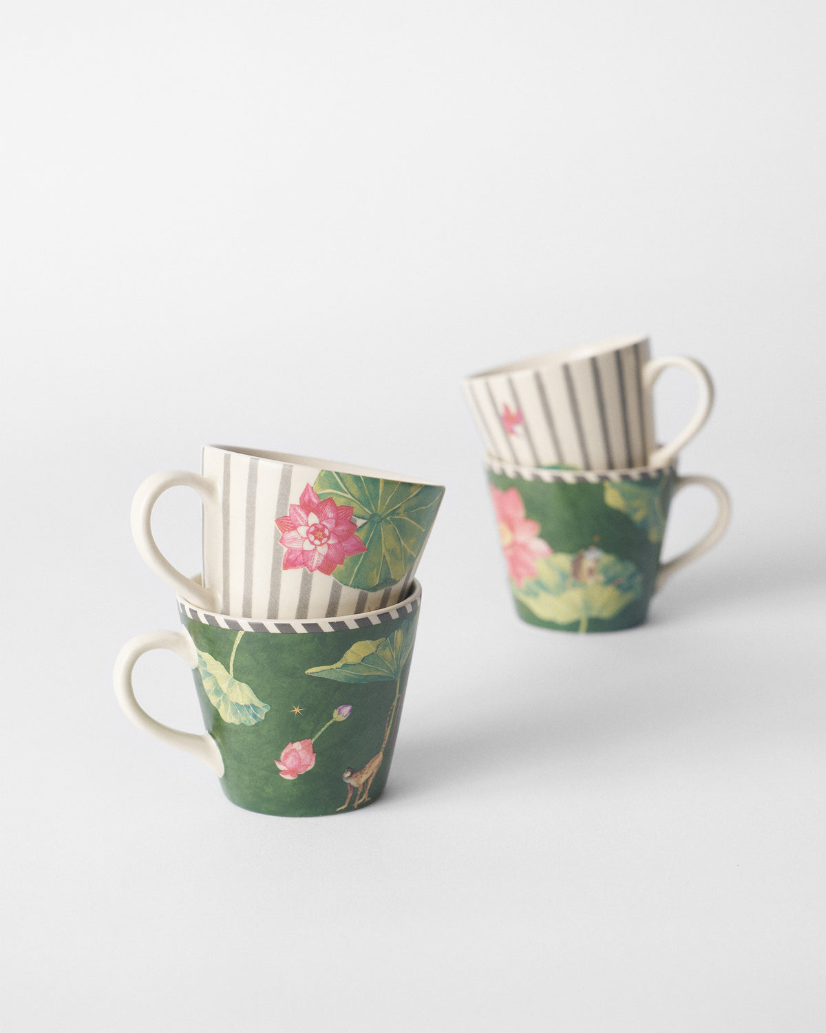 Two stacks of Float espresso mugs with lotus and monkey prints.