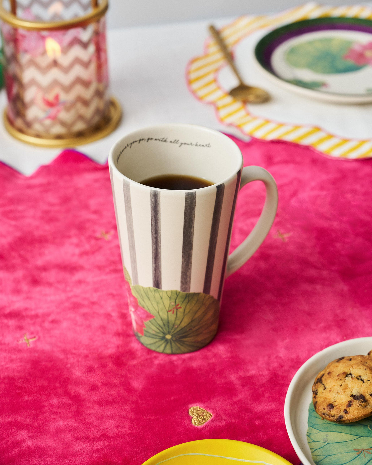 Tall Float mug with lily pad and lotus motifs filled with a dark drink.