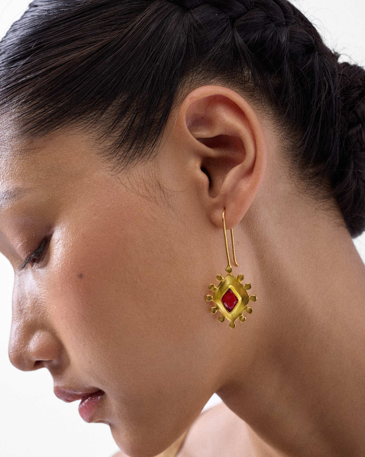 Side profile of gold garnet barfi drops with a beaded border.