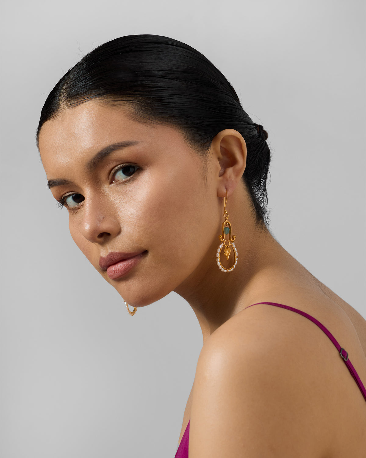 Person wearing gold Peepal Patta danglers with pearls.