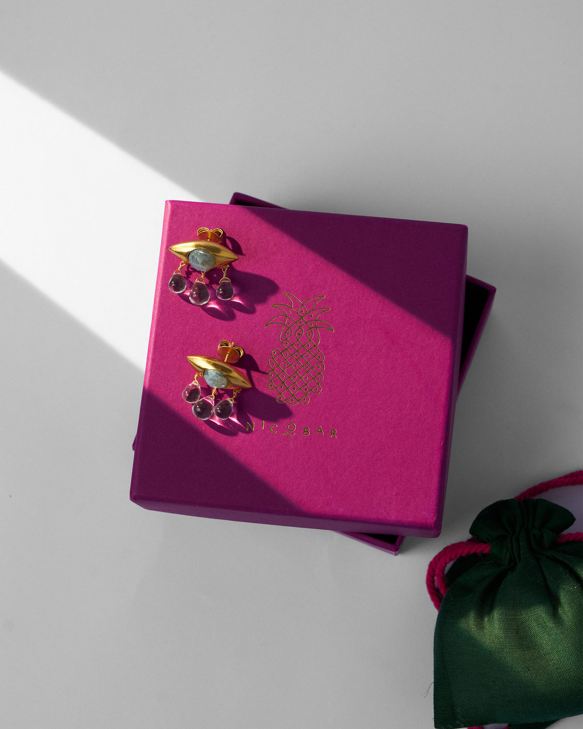 Gold Noor eye earrings on a pink Nicobar gift box.