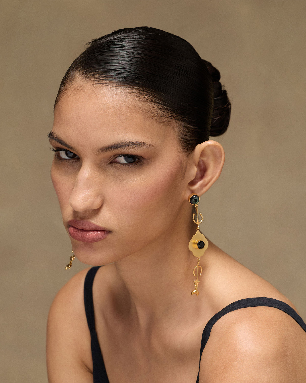 Person wearing Berber Eye Dangler with a black stone and gold drops.