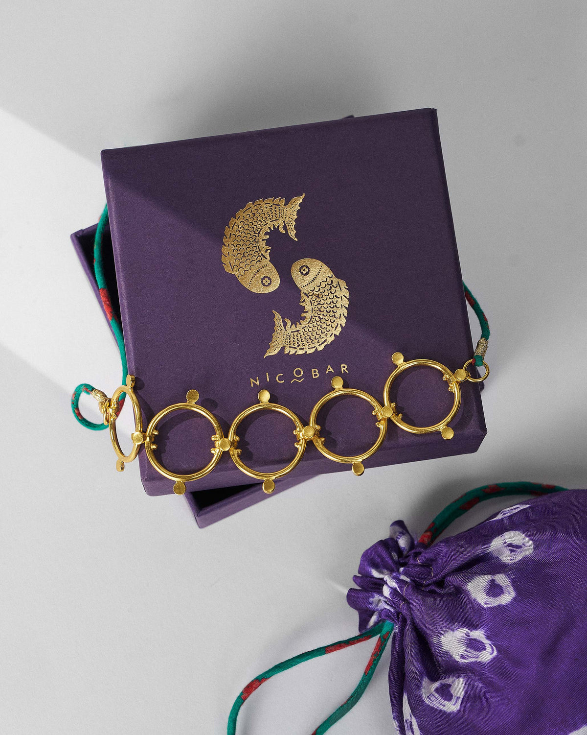 Panch Circle gold necklace on a purple Nicobar jewellery box.
