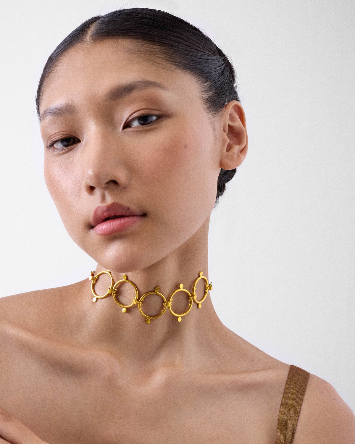 Person wearing a Panch Circle gold linked-circle choker.