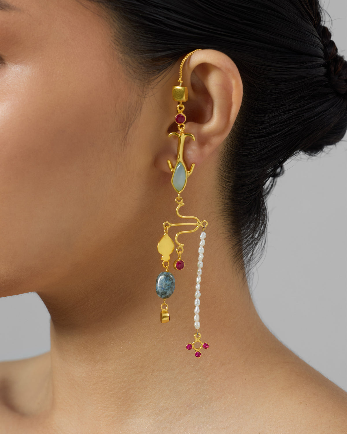 Side profile of a long gold Indus dangler with stones and pearls.