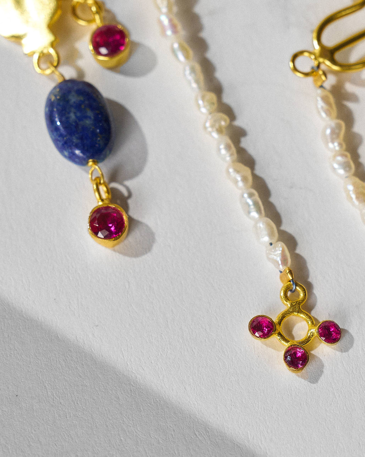 Close-up of blue stone, red drops, and pearl strand on Indus danglers.