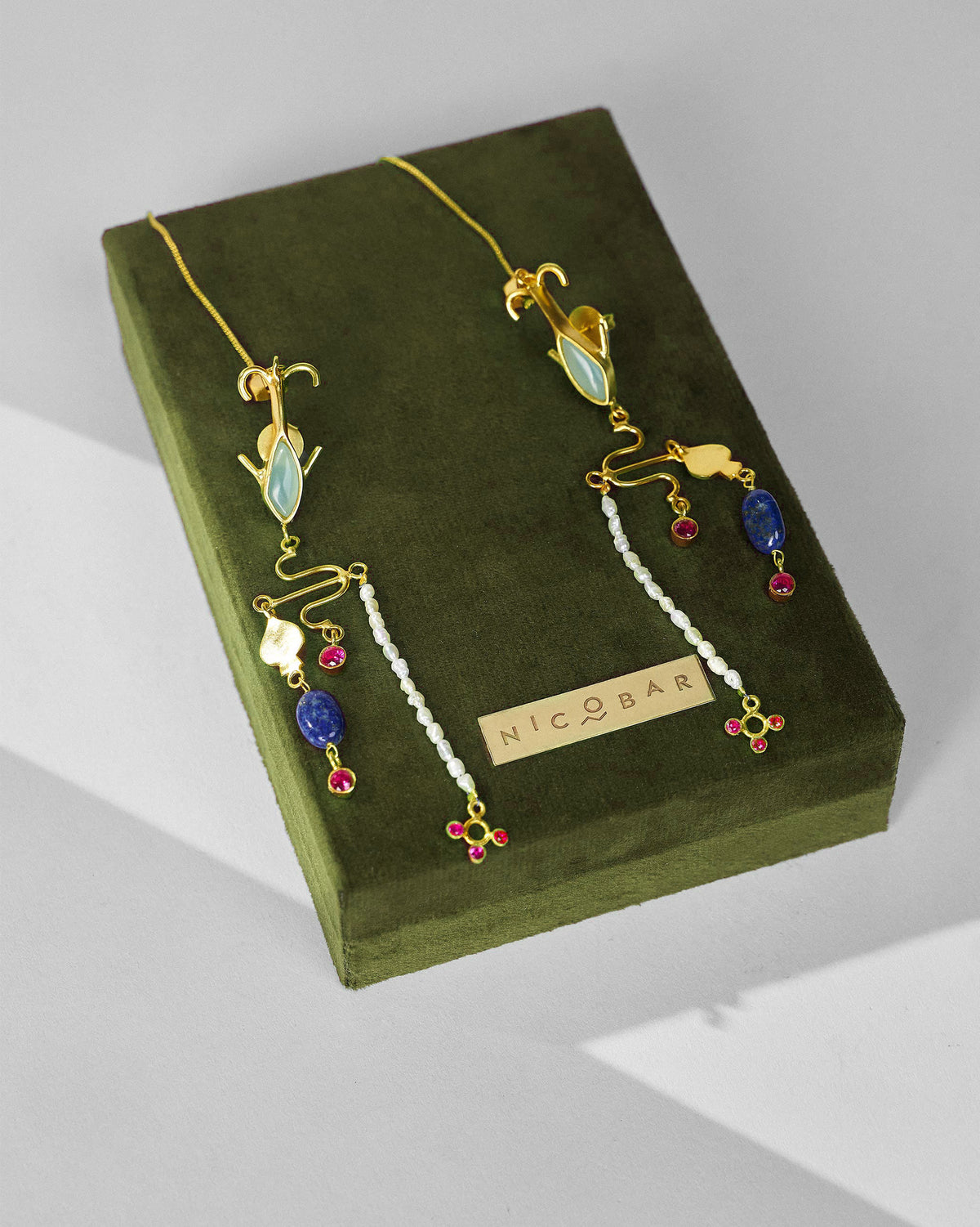 Gold Indus danglers on an olive Nicobar jewellery box.