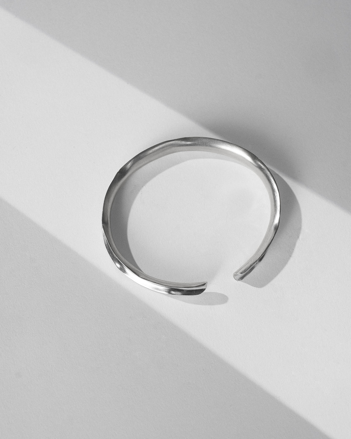 Thin silver Batur open cuff with a gently wavy band.