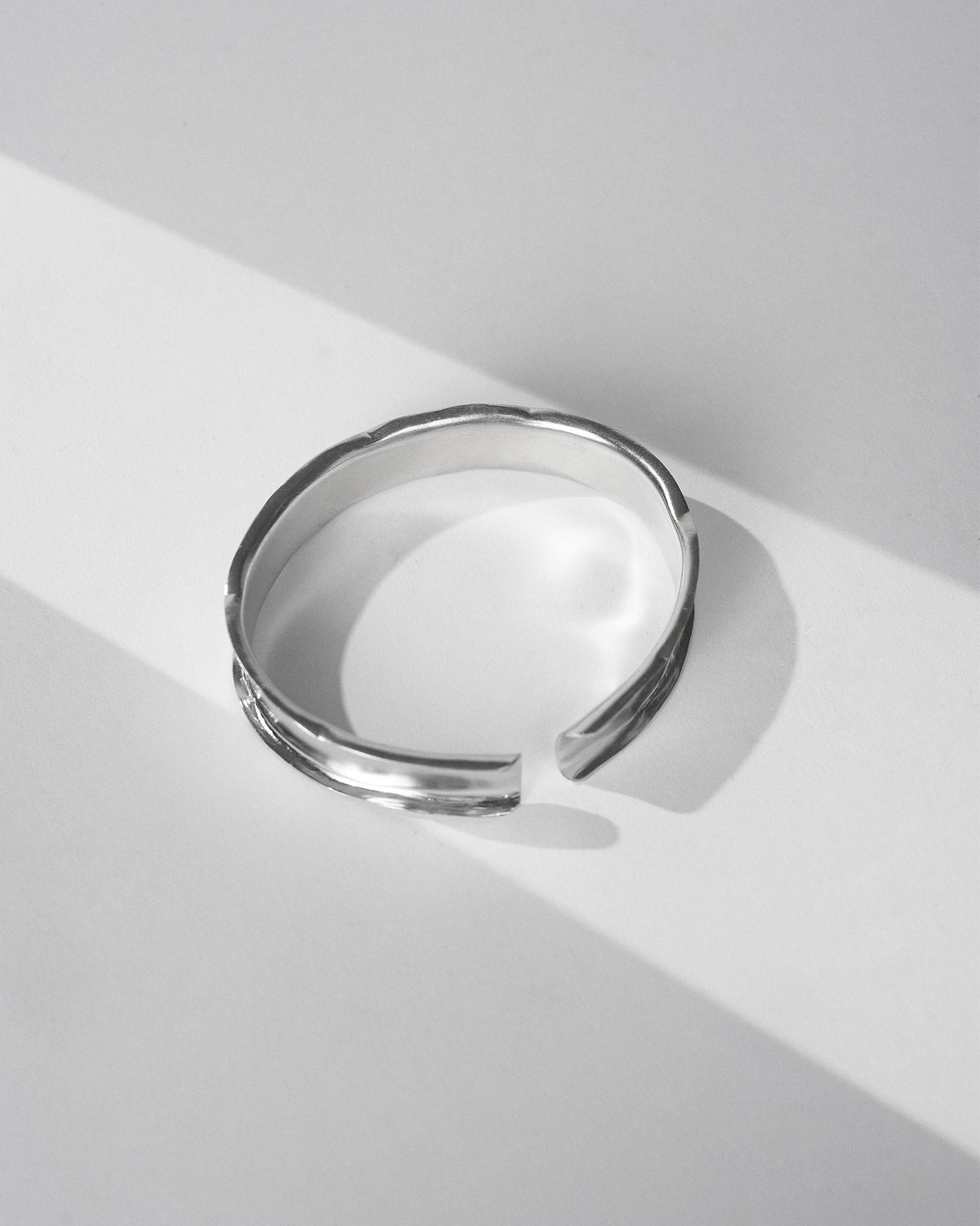 Thick silver Batur open cuff bangle with a concave band.