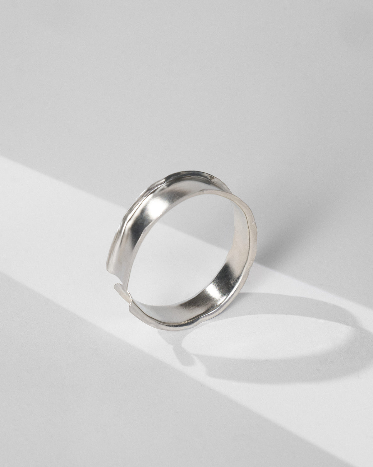 Thick silver Batur bangle with a concave band and flared edges.