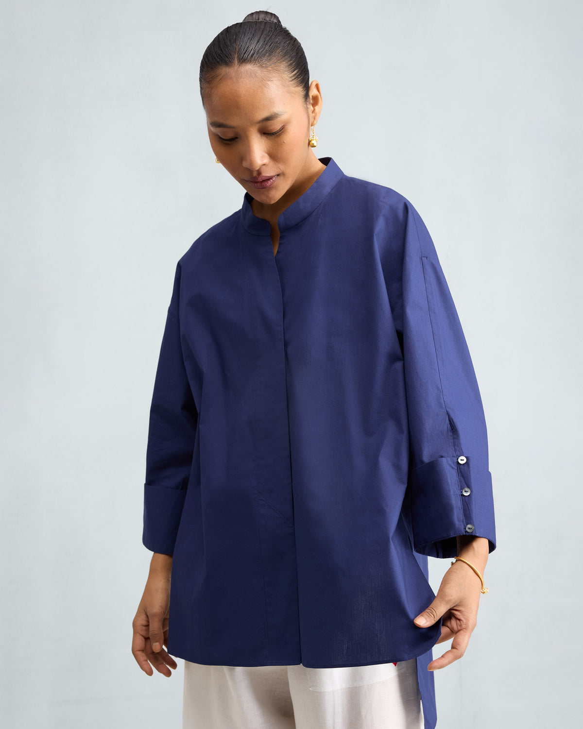 Person wearing an ink blue Cirrus Shirt with a band collar.