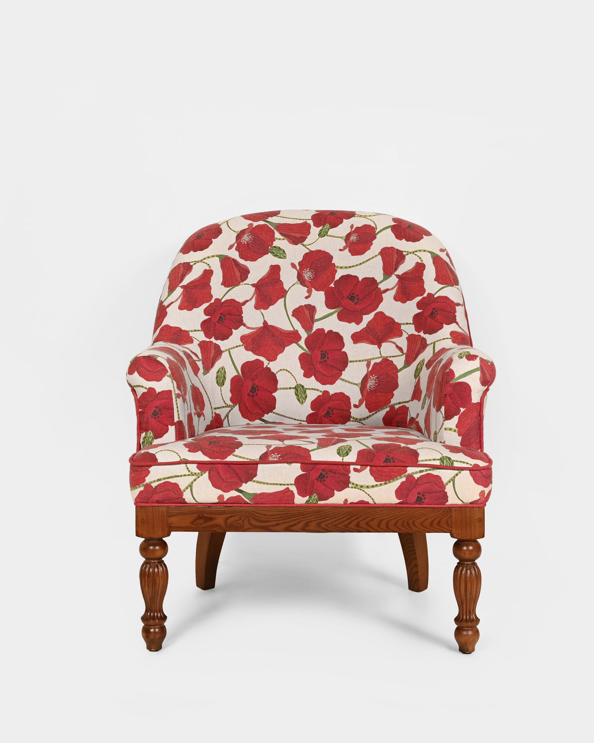 Meadow Chair in red poppy upholstery with turned wooden legs, seen from the front.