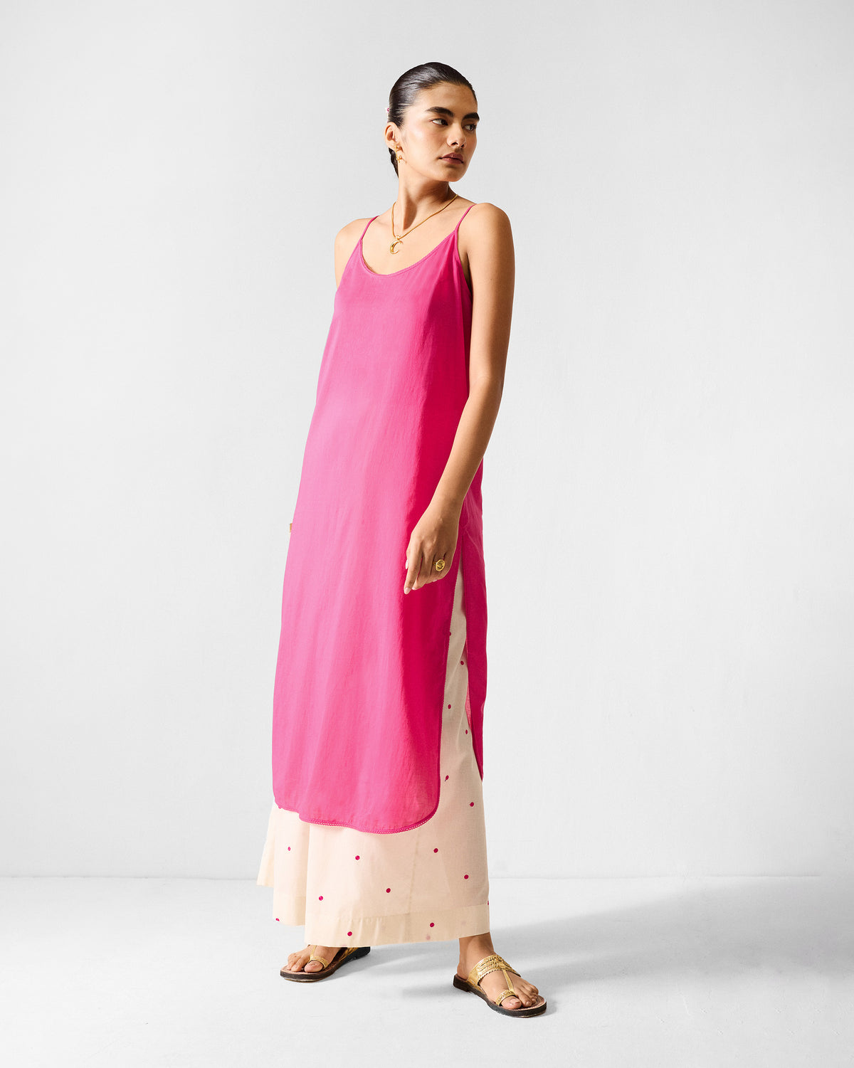Solid fuchsia Doda slip with side slits worn over trousers.