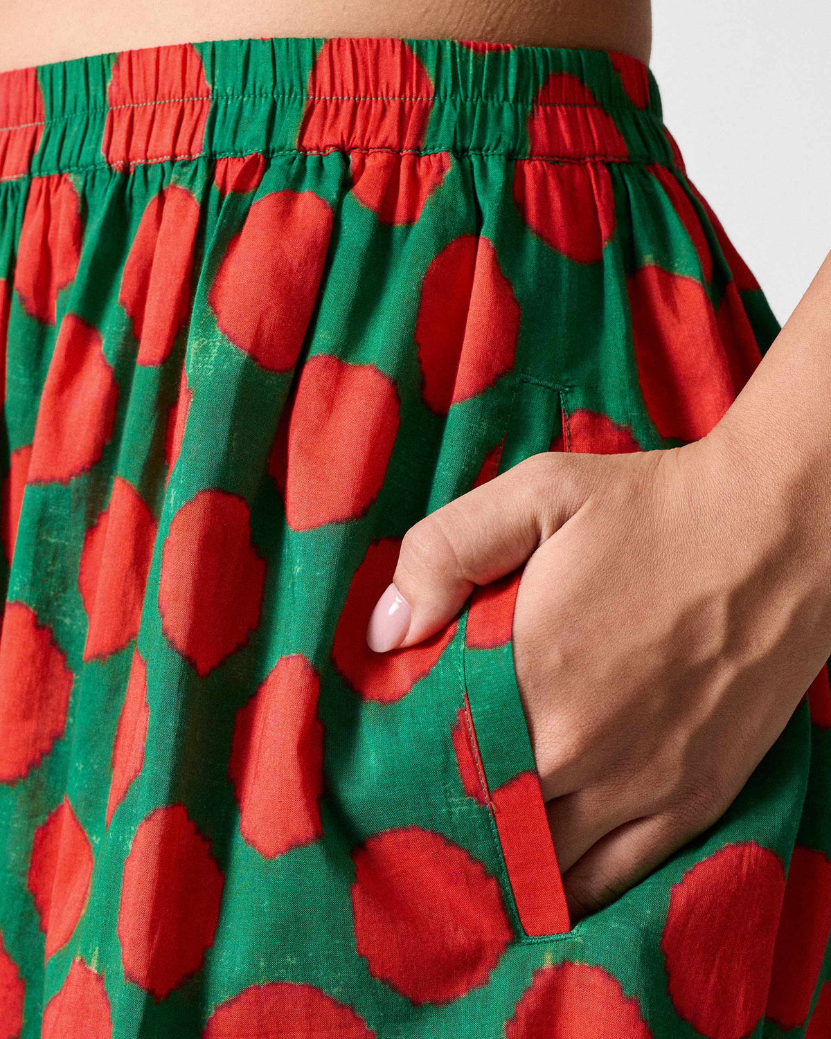 Close-up of Yoi Hem Pants showing a side pocket in the red dot print.