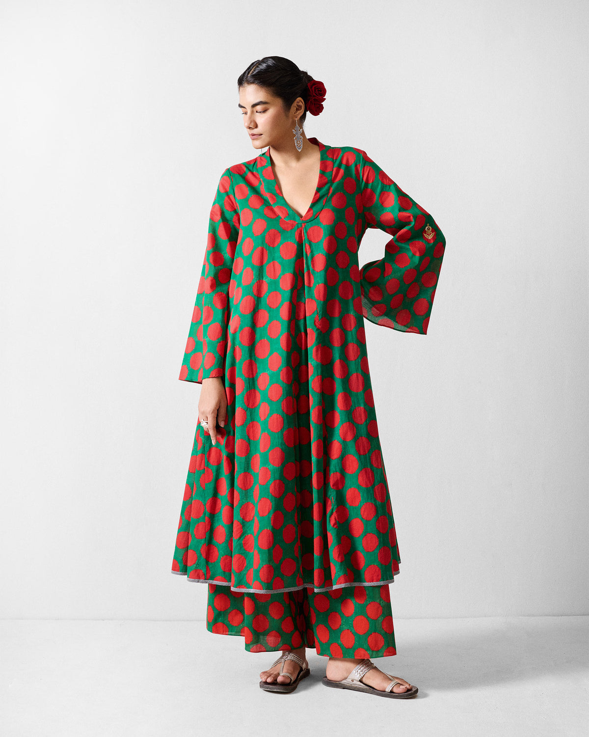 Person wearing Yoi Hem Pants with the wide legs visible beneath a long printed top.