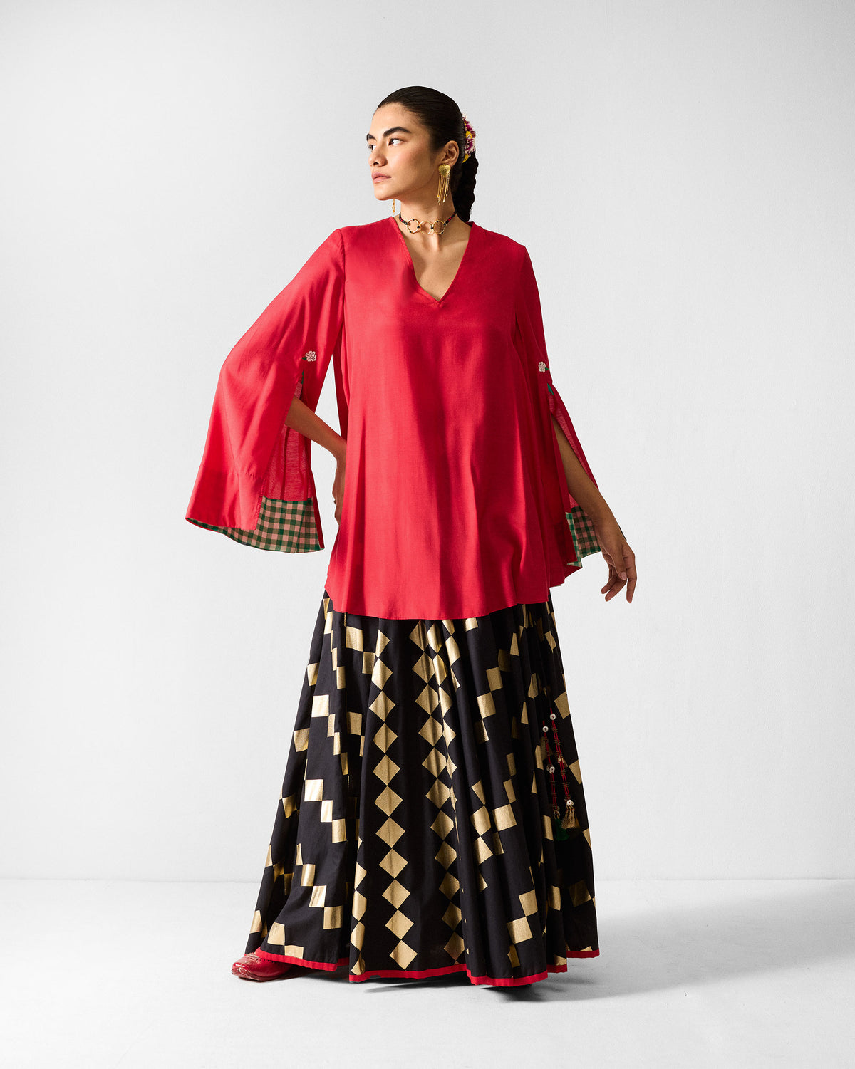 Black Afsar Skirt with gold foil print worn full length with a red top.