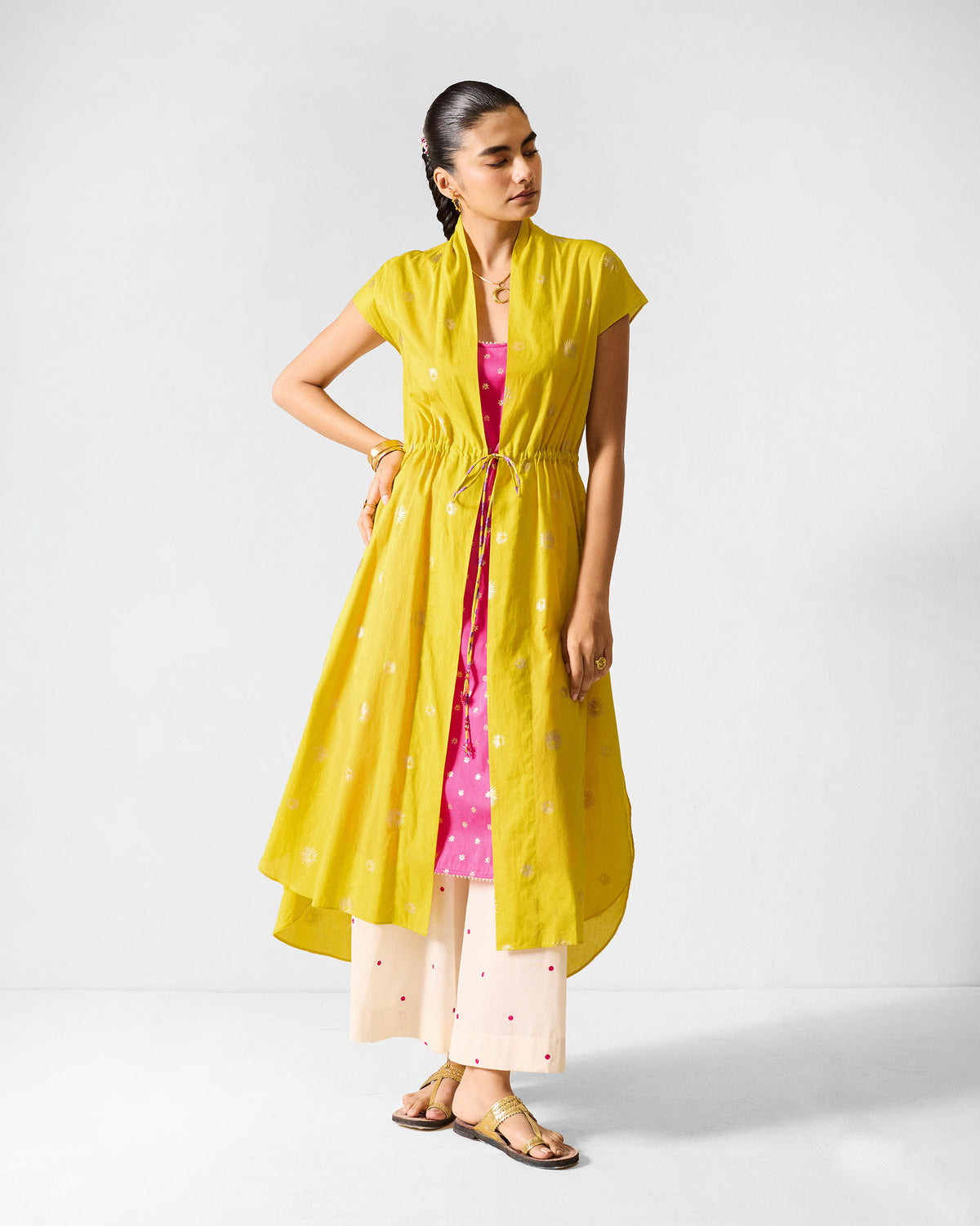 Person wearing a chartreuse Myra overlay with gold print and a drawstring waist.