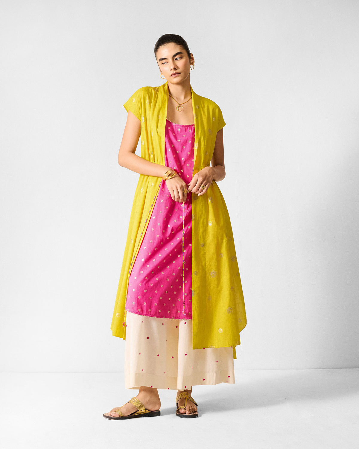 Person wearing a chartreuse and gold printed Myra overlay layered open.