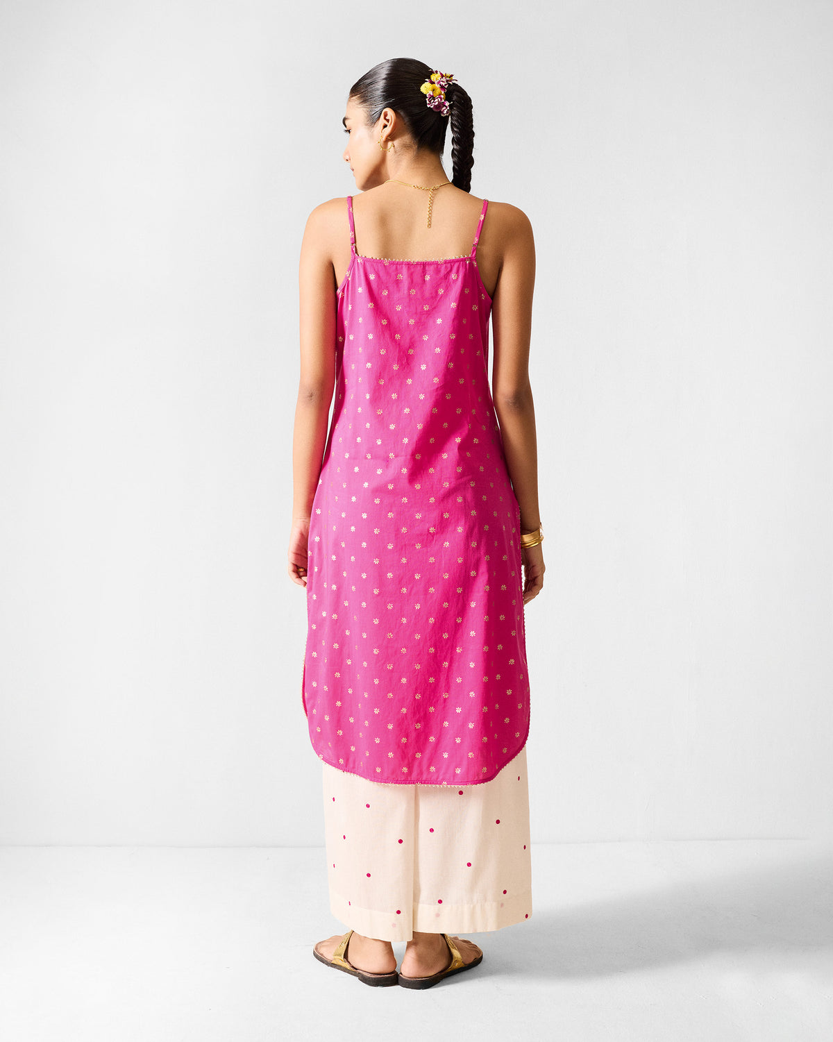 Back of a fuchsia Vintage Camisole with gold printed dots worn by a person.