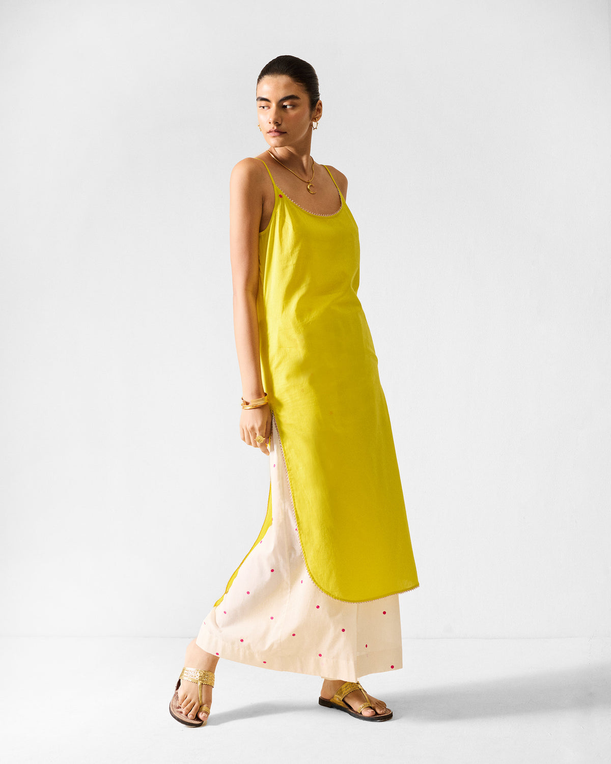 Side view of a lime Kumaon slip with a curved hem.