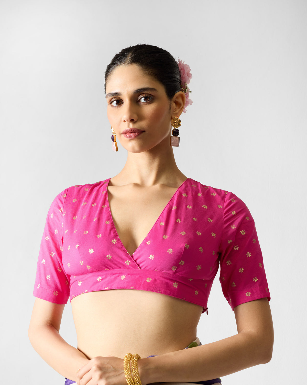 Person wearing fuchsia Ira Blouse with small gold printed flowers.
