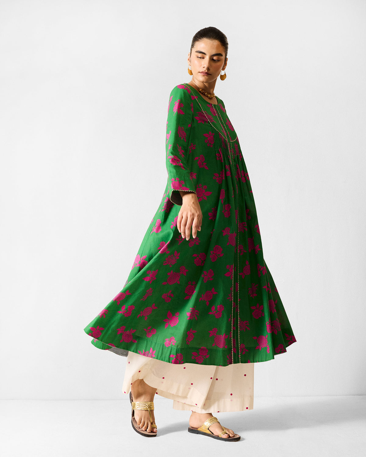 Person wearing a flared green and fuchsia printed Ayat kurta in motion.