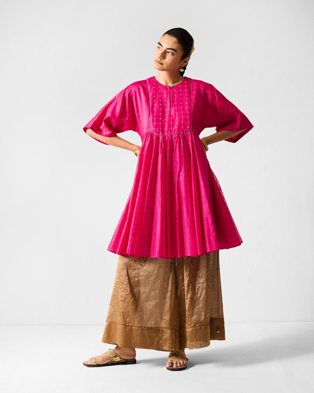 Person wearing a fuchsia Luna Afghan Kurta with a gold-dotted yoke.