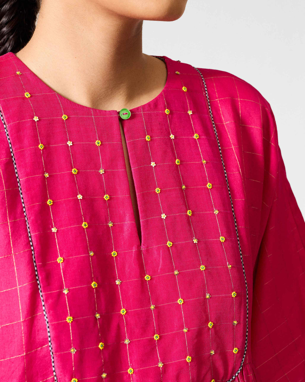 Close-up of yellow floral embroidery on a fuchsia Luna Afghan Kurta yoke.