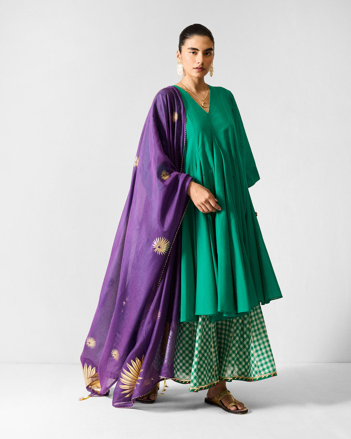 Person wearing a green Gusset Long Kurta with a purple printed dupatta.