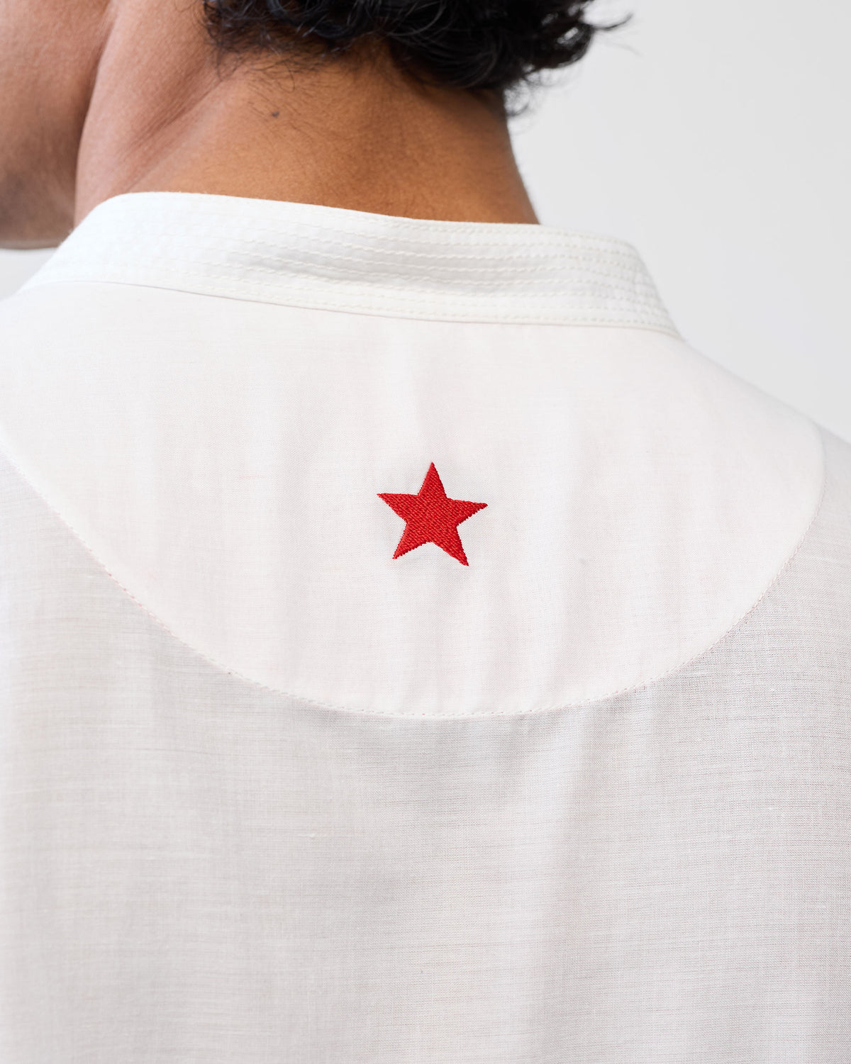 Close-up of the red embroidered star on the back of a white Neckband Kurta.