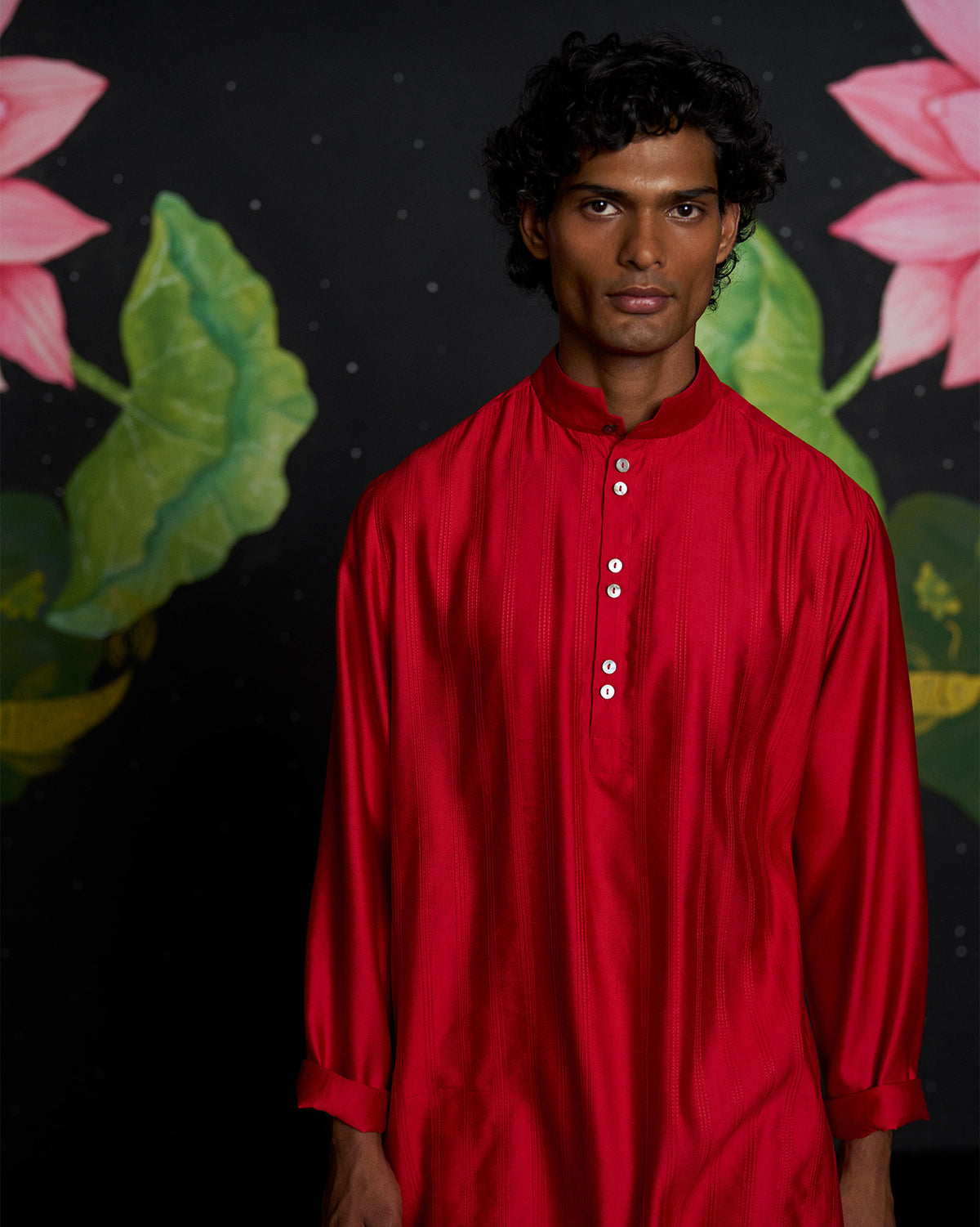 Person wearing a red Long Pleated Kurta with a mandarin collar and pearl buttons.