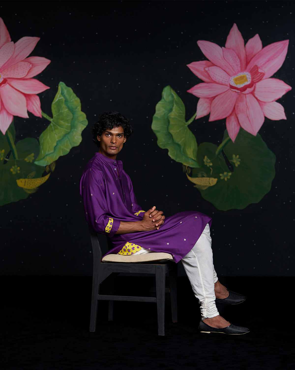 Person wearing a purple Neckband Kurta with yellow floral cuffs.