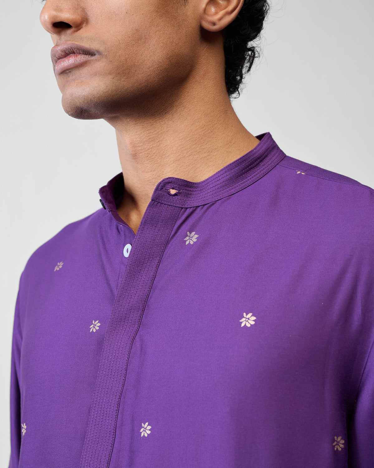 Close-up of a purple Neckband Kurta collar with gold floral buta.