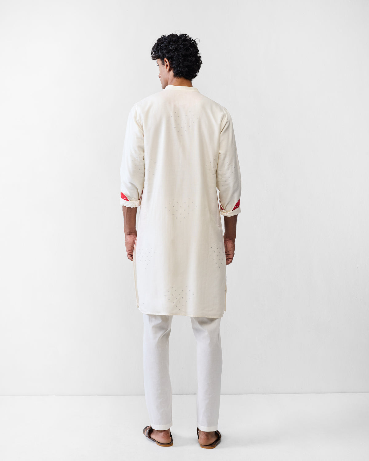Back of an ivory astral kurta with silver heart embroidery worn by a person.