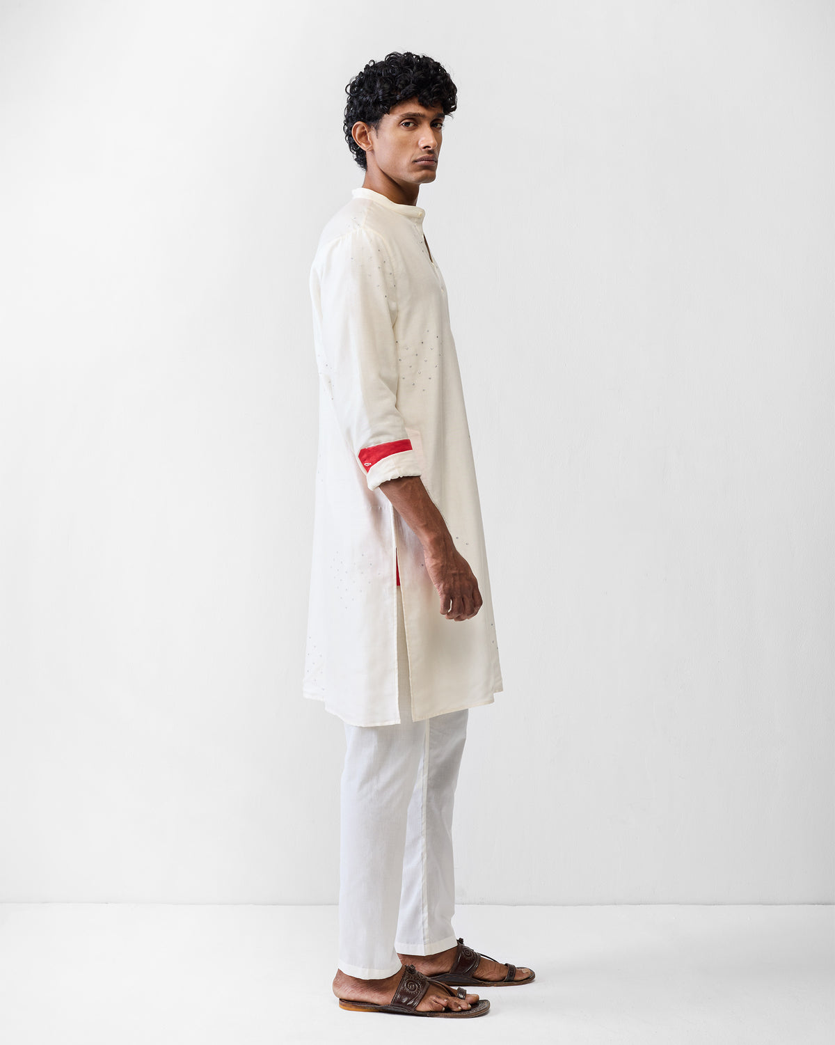 Side view of an ivory astral kurta with silver embroidery worn by a person.