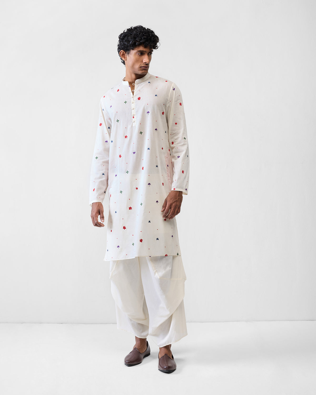 Person wearing an ivory Zenith Kurta with scattered flower embroidery.