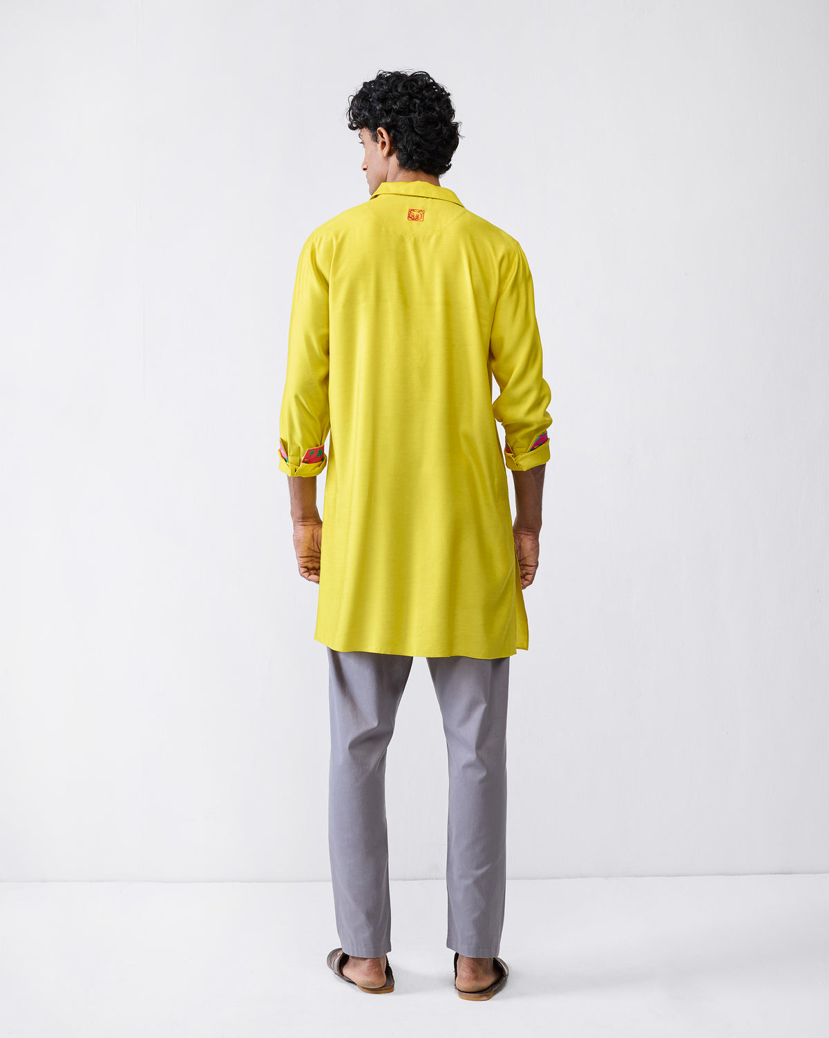 Back of a chartreuse Bouquet kurta with a red motif on the yoke.