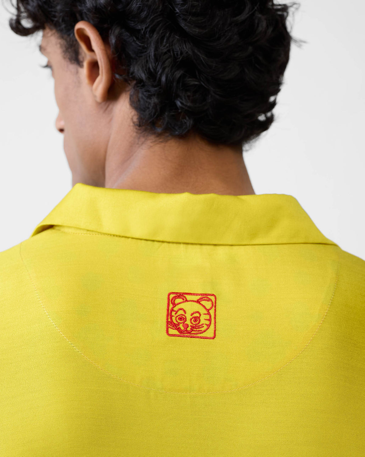 Close-up of a red tiger embroidery on a chartreuse Bouquet kurta.