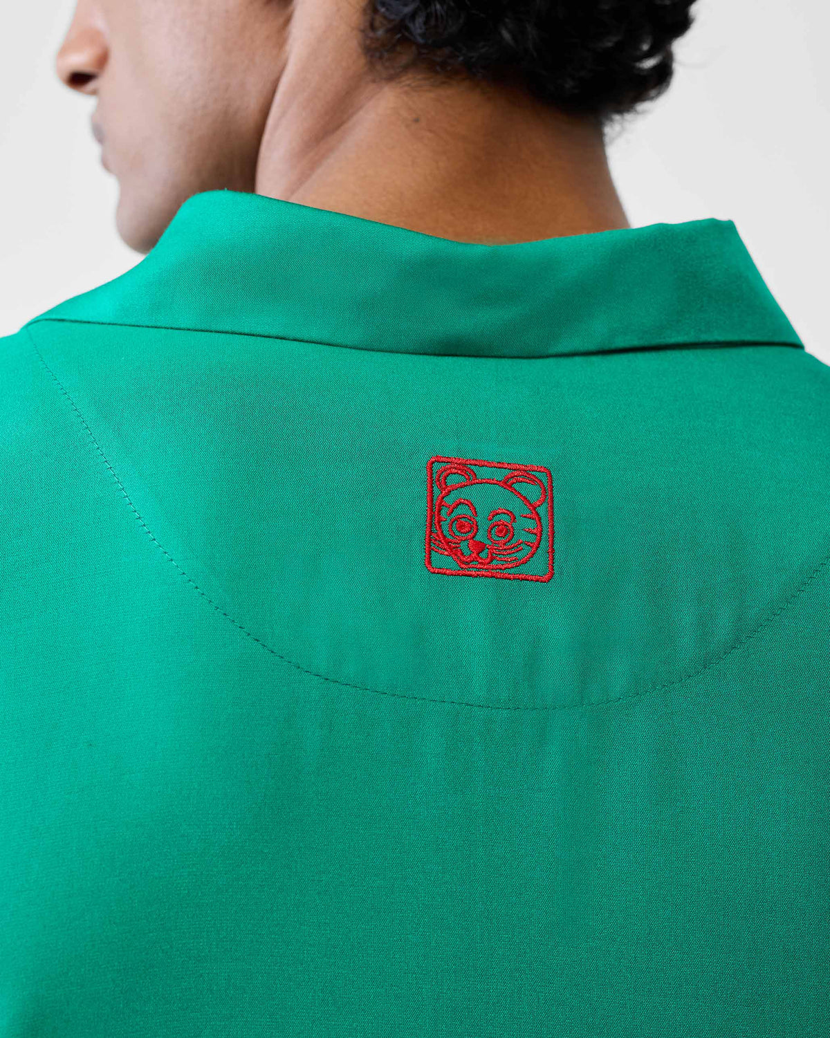 Close-up of a red embroidered motif on an emerald green Bouquet kurta.