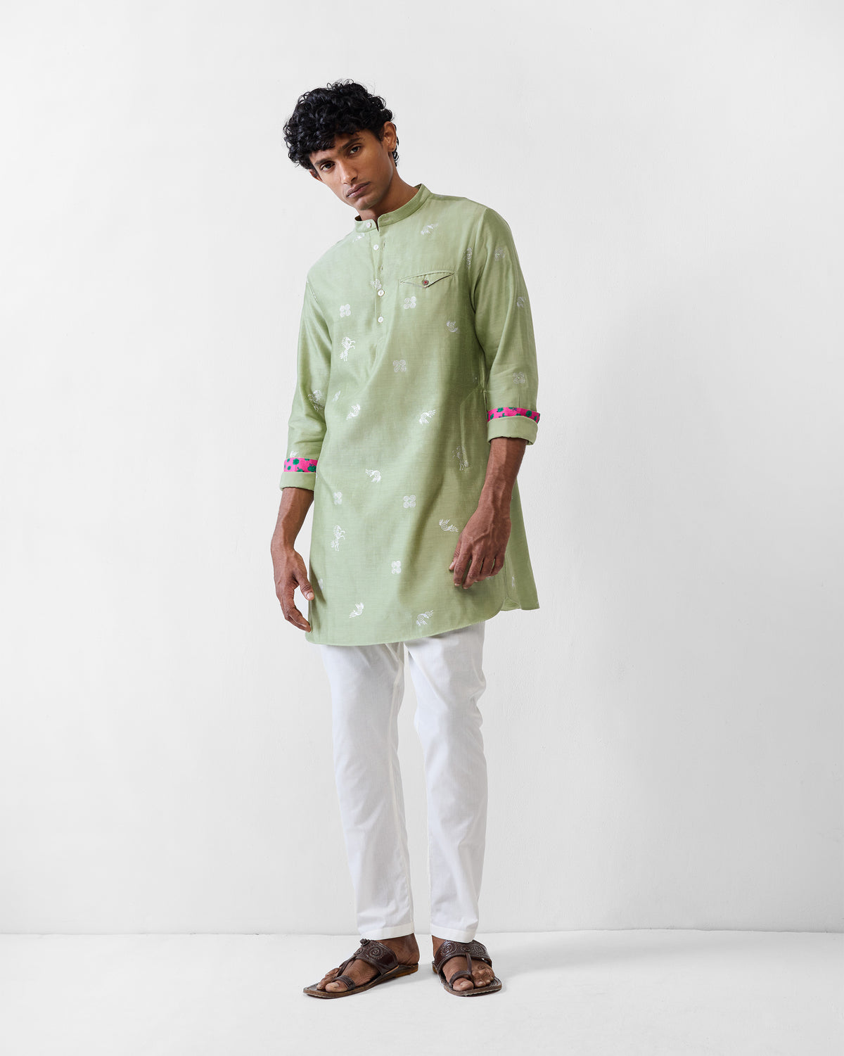 Person wearing a mint Fort kurta with pink and blue contrast cuff lining.