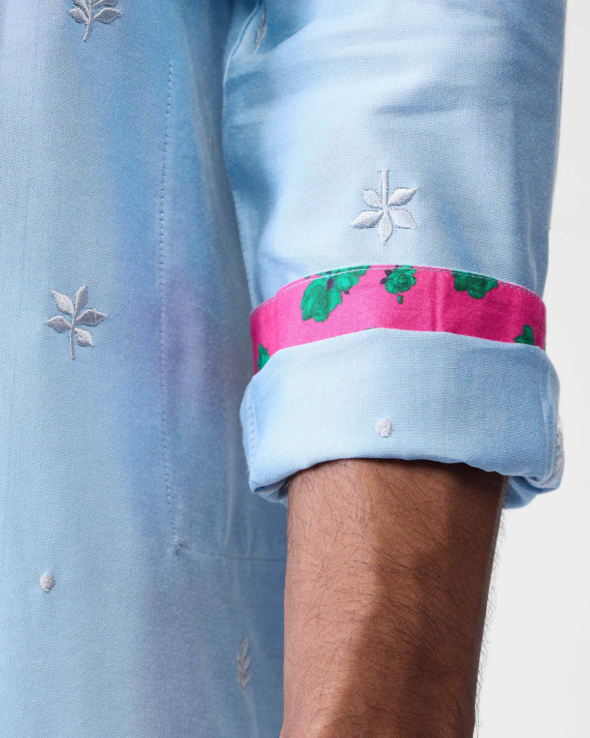 Close-up of a light blue Rey kurta sleeve showing embroidery and pink lining.