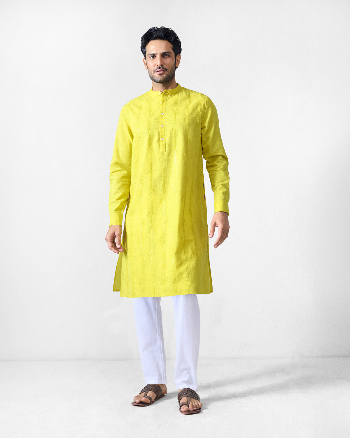 Person wearing a chartreuse Ibn Kurta with a band collar and knee-length hem.